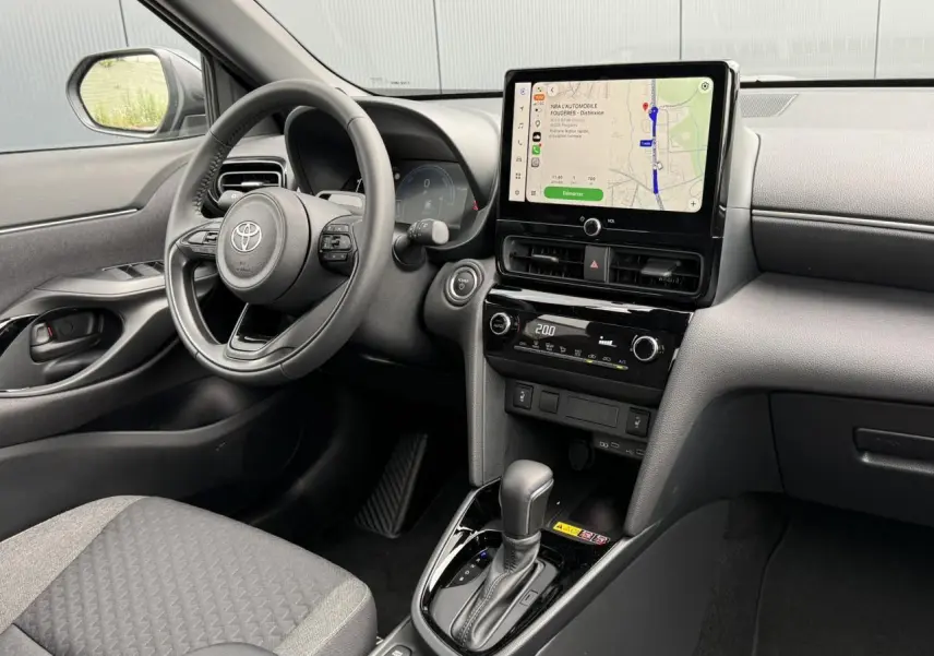 Vue intérieure côté conducteur de la Toyota Yaris Cross 1.5 Hybrid 116 Design avec écran tactile et volant cuir noir.