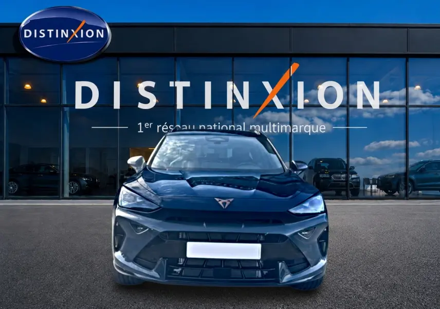 Vue frontale du CUPRA Formentor bleu fjord 2026 avec logo distinctif et calandre sportive devant un showroom Distinxion.