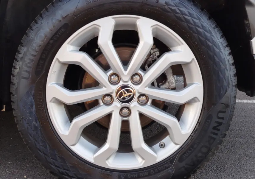 Gros plan sur la jante alliage argentée du Toyota Corolla Cross 1.8 140ch Dynamic avec logo Toyota au centre.