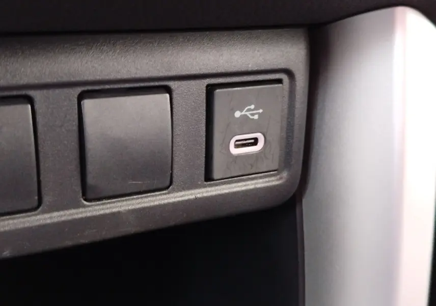 Gros plan sur une prise USB-C intégrée dans la console centrale du Toyota Corolla Cross gris minéral 2025.