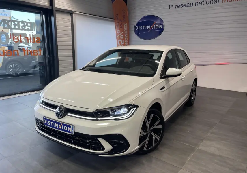 Volkswagen Polo 2024 blanche vue 3/4 avant en intérieur avec jantes alliage R-Line et calandre spécifique.