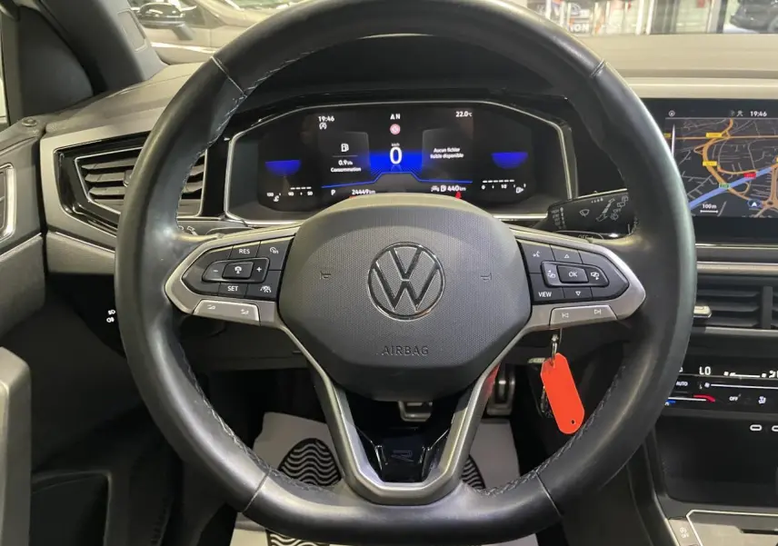 Vue intérieure centrée sur le volant cuir noir multifonction d'une Volkswagen Polo 2024 R-Line avec tableau de bord digital.