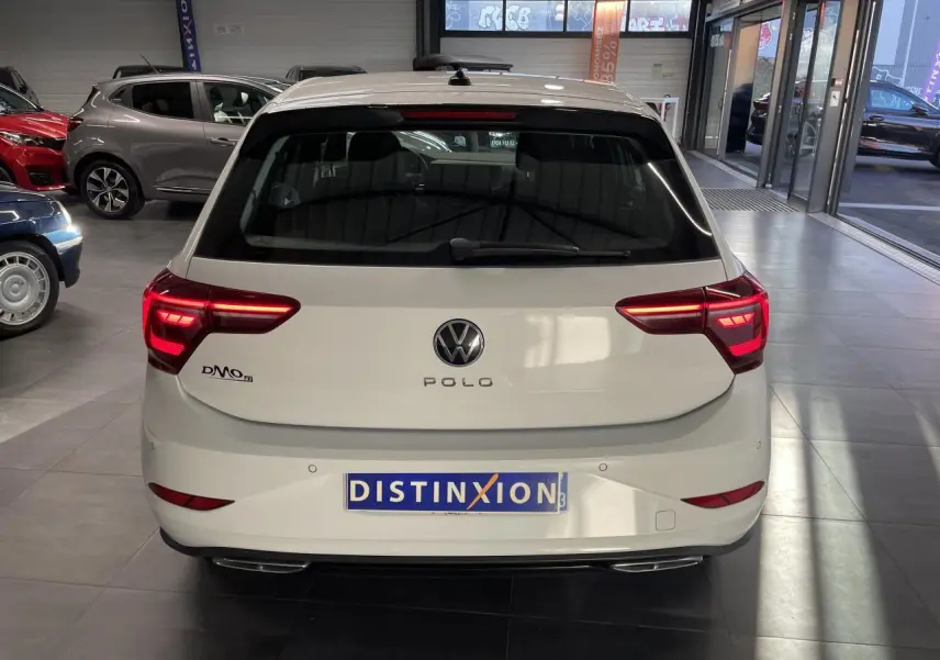 Vue arrière d'une Volkswagen Polo blanche 2024 R-Line avec feux LED et double sortie d'échappement en concession.
