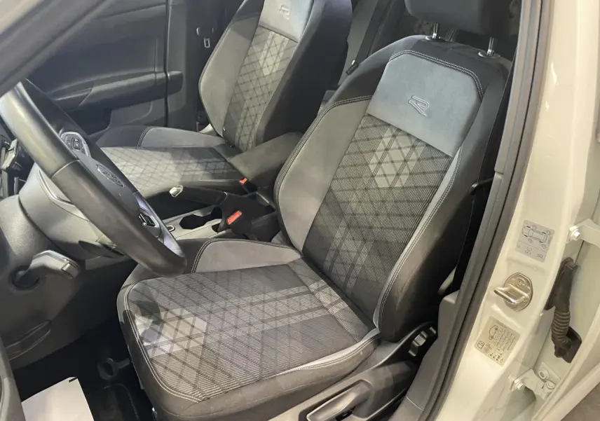 Vue intérieure côté conducteur de la Volkswagen Polo 1.0 TSI R-Line 2024 blanche, sièges tissu Karoso avec logo R brodé.