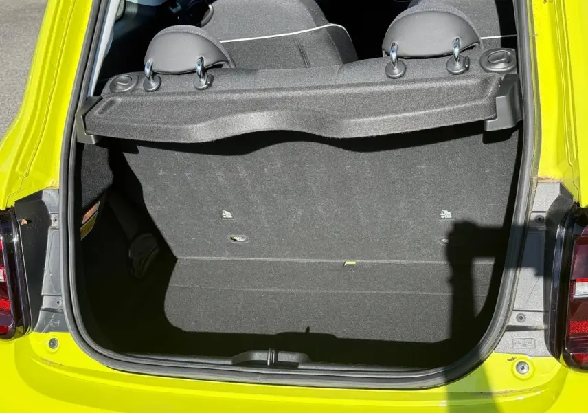 Coffre ouvert vu de l'arrière d'une FIAT 500 électrique jaune Amalfi avec banquette arrière rabattable visible.