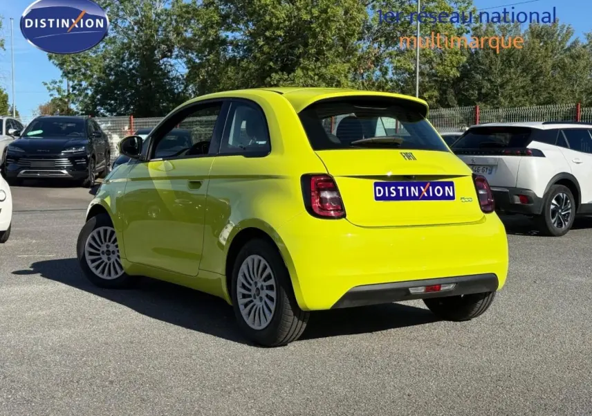 Vue 3/4 arrière droite d'une FIAT 500 électrique jaune Amalfi avec becquet et feux arrière LED sur parking.
