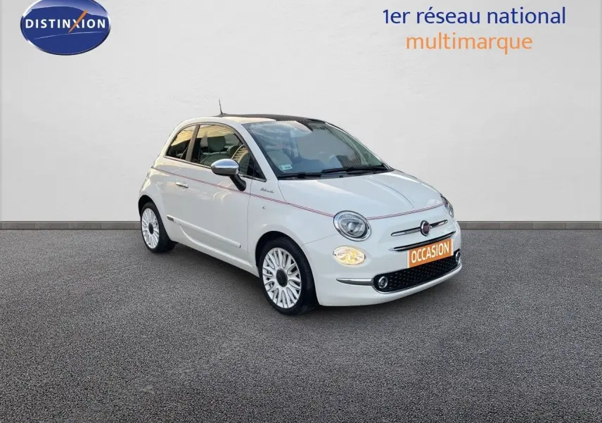 Fiat 500 1.0 Hybrid blanche vue 3/4 avant droit avec jantes blanches et phares allumés sur fond neutre.