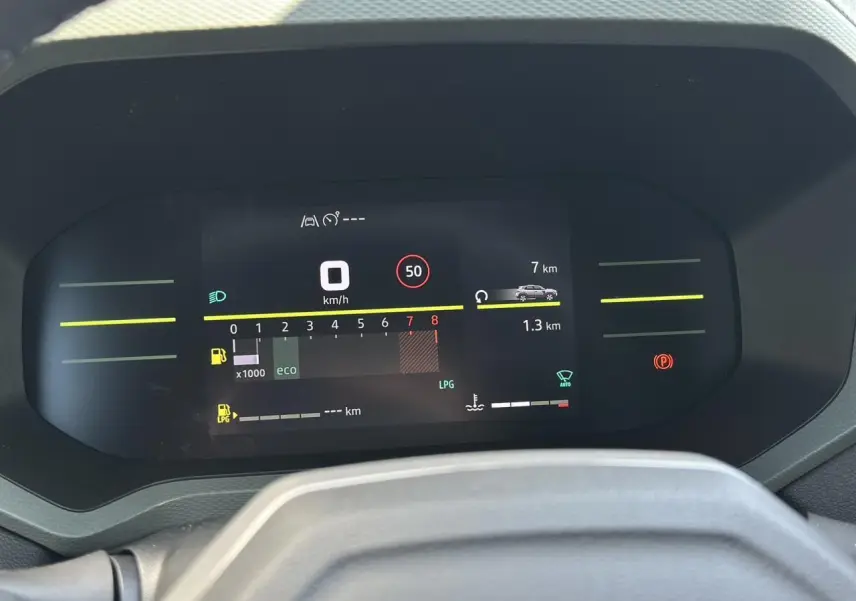 Tableau de bord digital 7 pouces du Dacia Duster ECO-G 100 Extrême affichant vitesse et alertes, vue frontale intérieure.