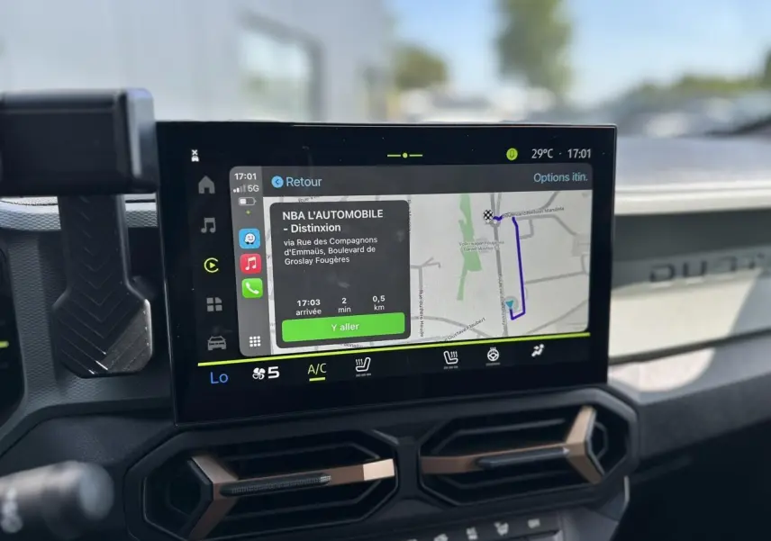 Écran tactile 10 pouces du tableau de bord du Dacia Duster 2025, avec navigation affichée, intérieur gris.