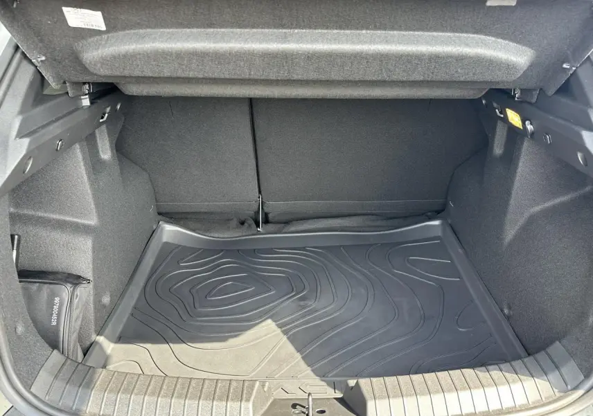 Coffre ouvert du Dacia Duster ECO-G 100 Extrême gris Schiste, montrant le tapis de sol caoutchouc texturé.