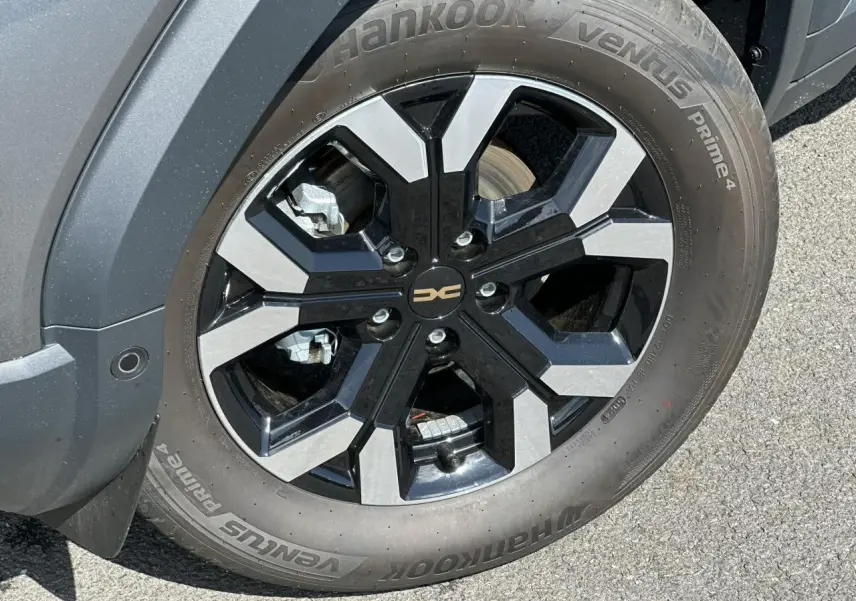 Gros plan sur la jante alliage 17 pouces semi-diamantée noire et grise du Dacia Duster Gris Schiste côté avant droit.