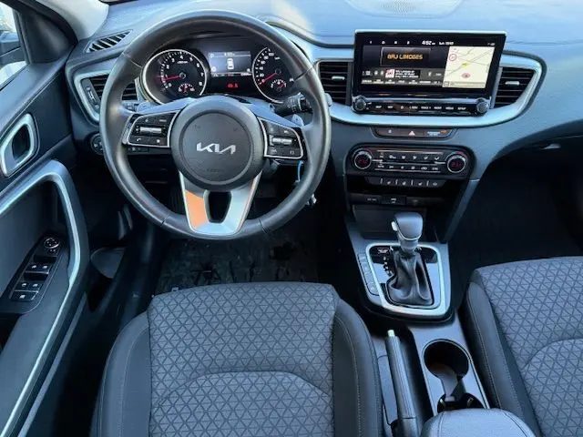 Intérieur de la KIA CEE'D 2024, vue centrale sur la console avec écran tactile et levier de boîte automatique.