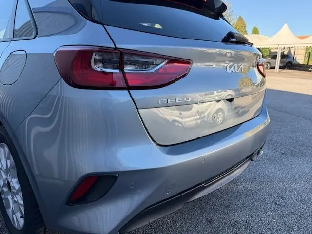 Vue 3/4 arrière droite d'une KIA CEE'D 2024 argent lunaire avec feux arrière LED et logo distinctif sur le hayon.