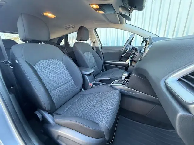 Intérieur de la KIA CEE'D 2024 en vue latérale droite, sièges tissu noir à motifs géométriques et tableau de bord moderne.