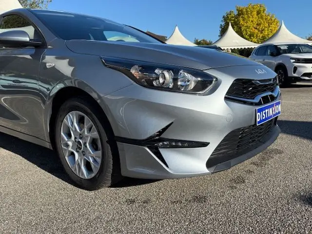 Vue 3/4 avant gauche d'une KIA CEE'D 2024 argent lunaire avec phares LED et calandre noire distinctive.