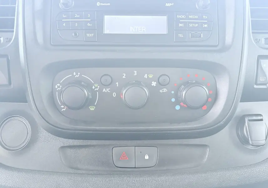 Vue rapprochée du tableau de bord de l'Opel Vivaro 2018 montrant les commandes de climatisation et la radio intégrée.