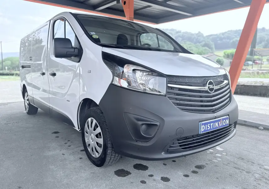 Vue 3/4 avant gauche d’un Opel Vivaro blanc avec pare-chocs avant noir mat sous abri.