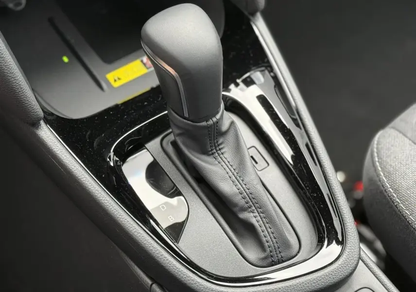 Gros plan sur le levier de vitesses automatique noir brillant de la Toyota Yaris Cross 1.5 Hybrid 116 Design.