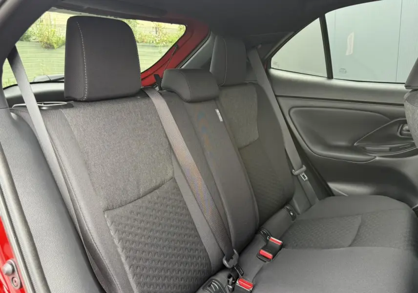Vue intérieure des sièges arrière noirs de la Toyota Yaris Cross 1.5 Hybrid 2026, avec ceinture de sécurité visible côté gauche.