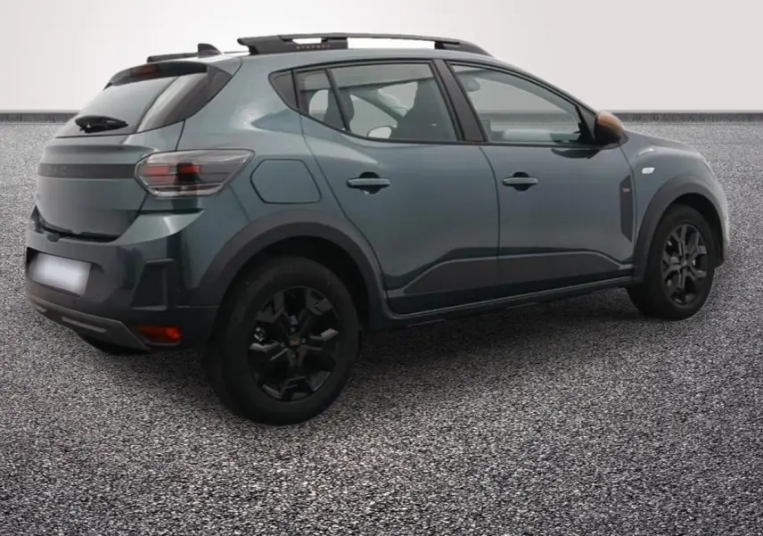 Vue 3/4 arrière droite d'une Dacia Sandero Extreme Eco-G 120 auto 2026 en vert avec jantes noires et barres de toit.