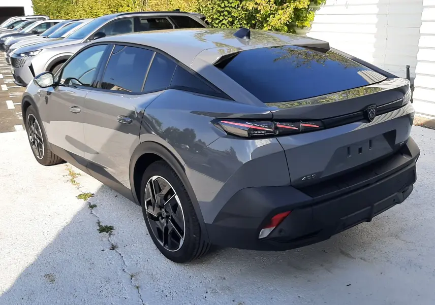 Vue 3/4 arrière droite d'une Peugeot 408 gris selenium avec feux arrière LED et toit noir brillant.