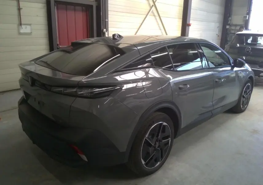 Peugeot 408 gris selenium vue de profil côté gauche, avec jantes noires et détails modernes sur la carrosserie.