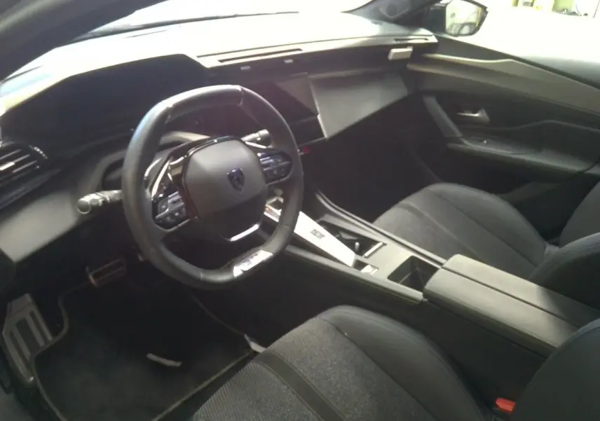 Vue 3/4 avant droit de la Peugeot 408 gris selenium avec rétroviseur noir brillant et jantes noires biton.