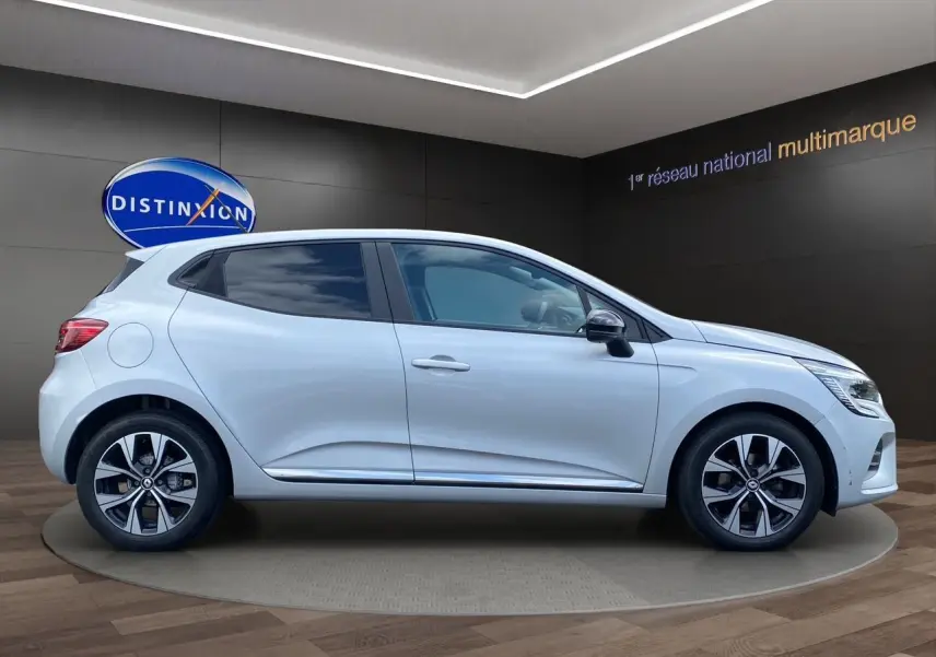 Profil côté droit d'une Renault Clio V gris Highland 2023 avec jantes alliage et vitres teintées en showroom.