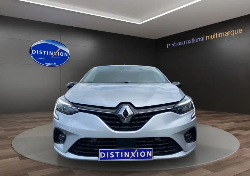 Vue frontale d'une Renault Clio V TCE 90 Evolution gris Highland avec calandre noire et logo Renault bien visible.