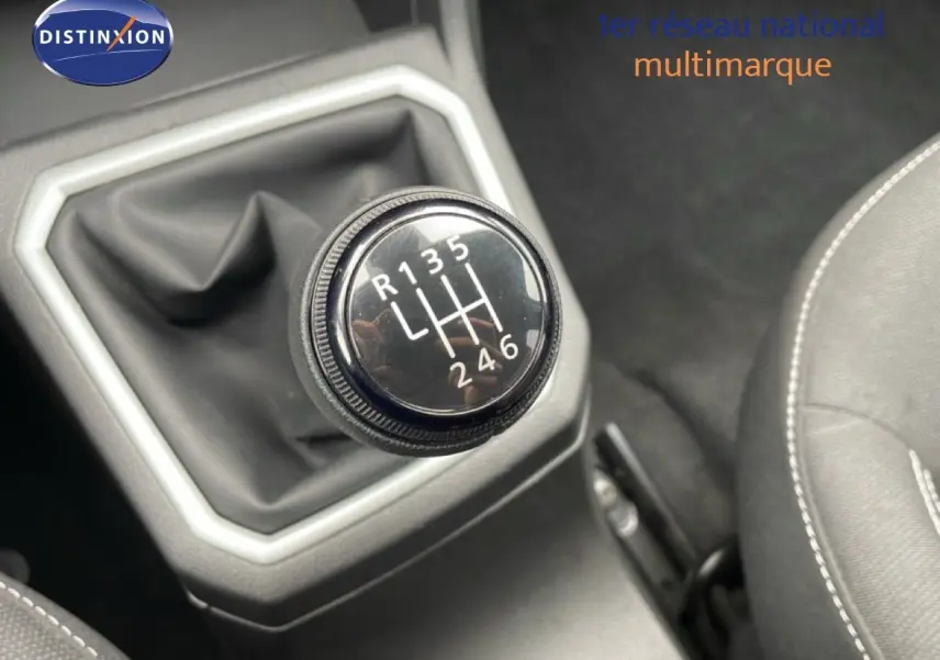 Gros plan sur le levier de vitesses manuel de la Dacia Jogger kaki lichen, intérieur tissu noir avec coutures blanches.