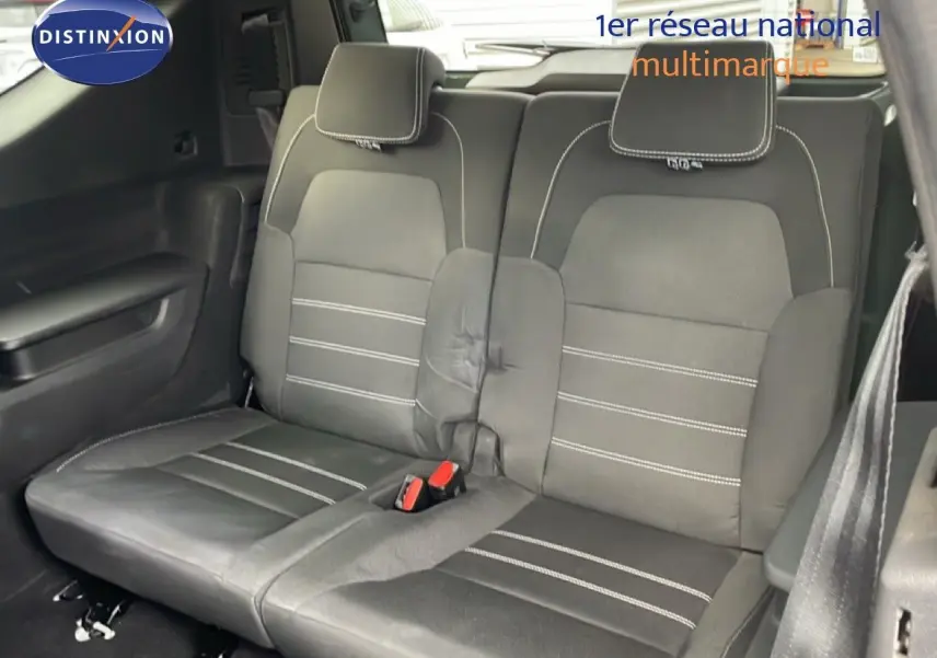Vue intérieure sur la banquette arrière en tissu noir avec surpiqûres blanches du Dacia Jogger 2025.