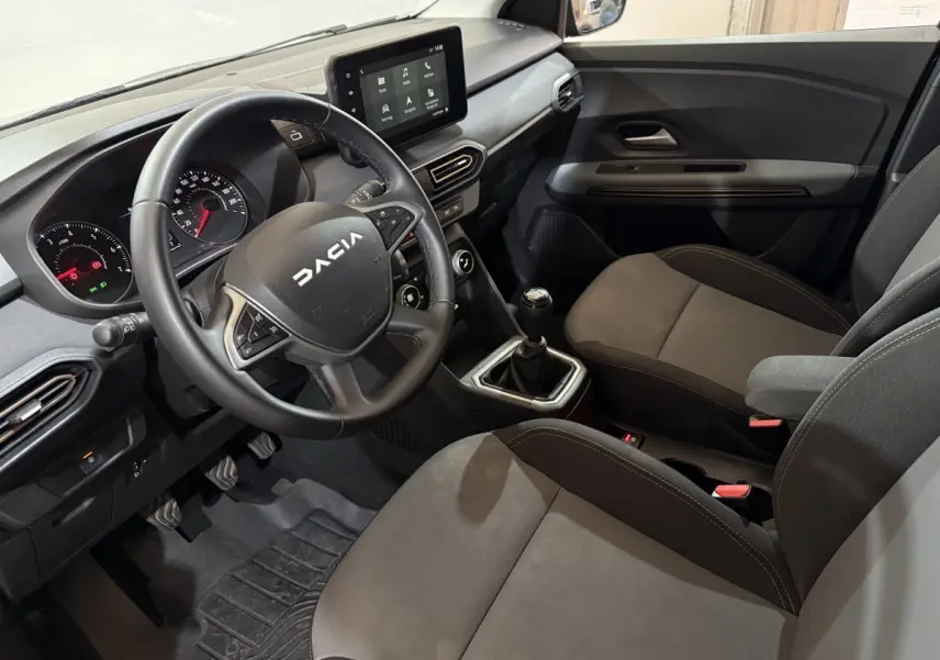 Vue intérieure côté conducteur de la Dacia Sandero Extreme+ 2024, volant cuir, boîte manuelle et écran tactile central.