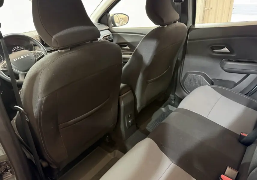 Vue arrière intérieure montrant les sièges tissu bicolores noirs et gris de la Dacia Sandero Extreme+ 2024.