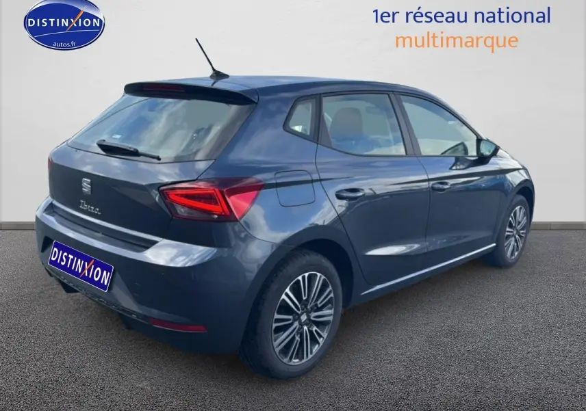 Vue 3/4 arrière droite d'une SEAT Ibiza 1.0 TSI 95 Copa gris magnétique avec feux arrière LED et jantes design.