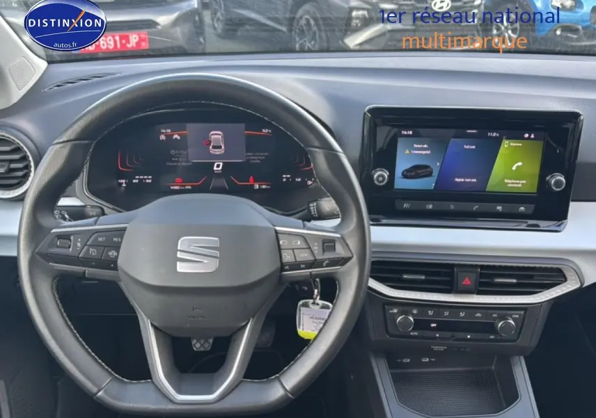 Vue intérieure centrée sur le volant cuir méplat et l'écran tactile HD du tableau de bord de la SEAT Ibiza gris magnétique.