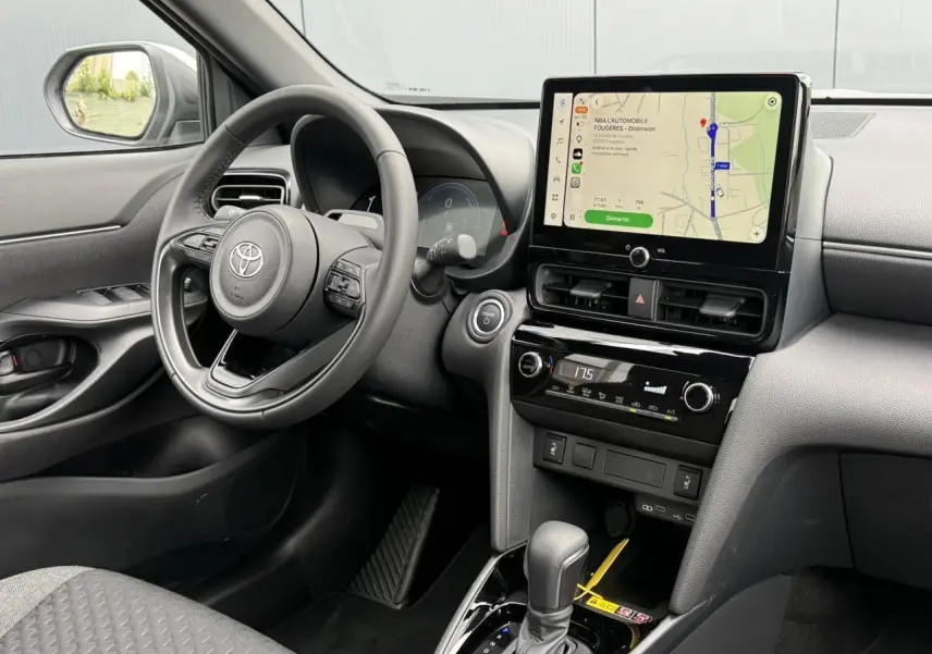 Vue intérieure côté conducteur de la Toyota Yaris Cross 1.5 Hybrid 116 Design avec écran tactile et volant cuir noir.