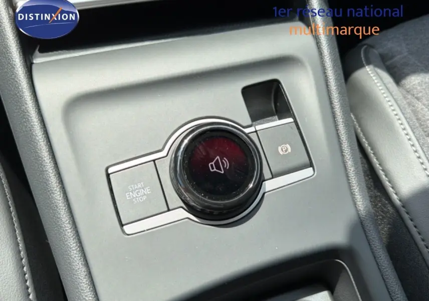 Gros plan sur la console centrale grise du Volkswagen Tiguan 2026, avec bouton start/stop et commande volume circulaire.