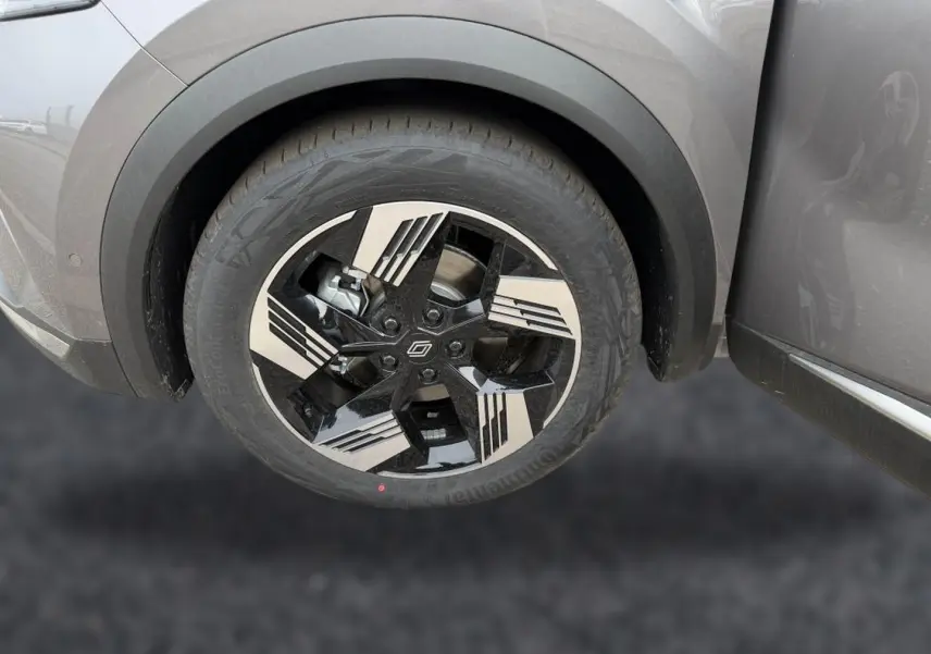 Gros plan sur la roue avant droite du Renault Symbioz gris cassiopée avec jante alu noire et argentée au design géométrique.