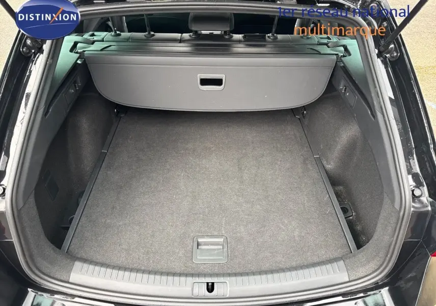 Coffre ouvert vu de l'arrière d'une CUPRA LEON ST noire Midnight Metal, montrant un espace de chargement propre et spacieux.