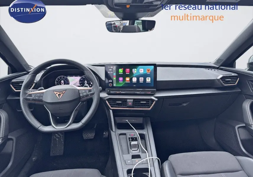 Intérieur noir du CUPRA LEON ST 2024, vue frontale sur le tableau de bord et le volant multifonction avec écran tactile central.