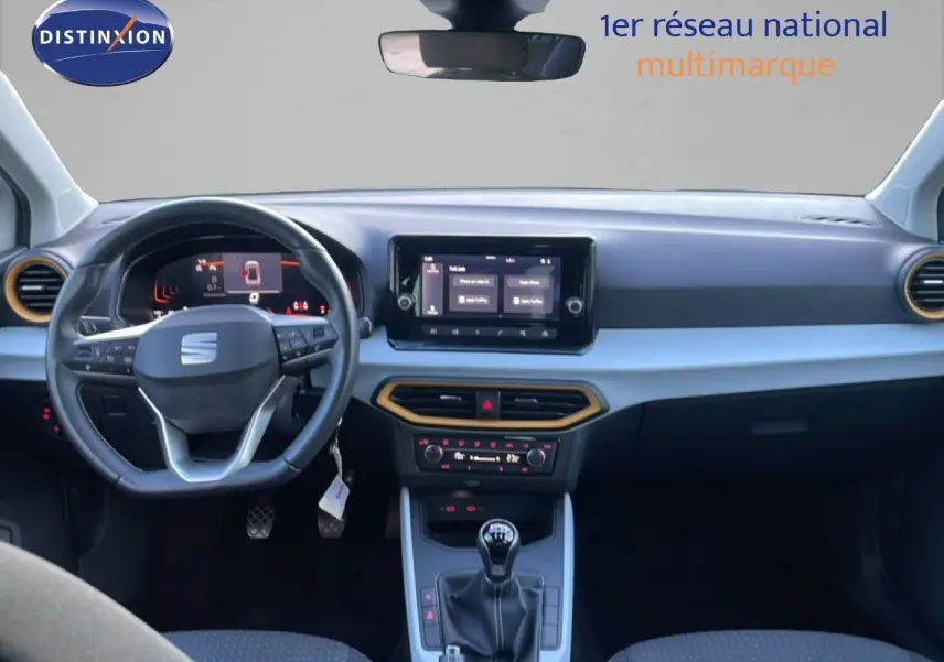 Vue intérieure frontale du tableau de bord du SEAT Arona blanc avec volant cuir multifonction et écran tactile central.