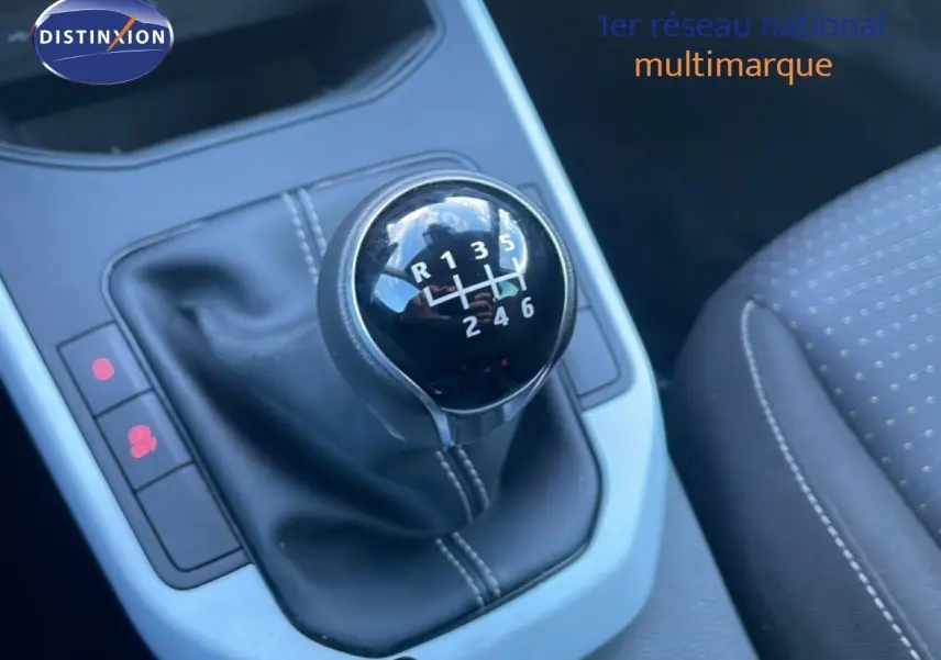 Gros plan sur le levier de vitesses manuel noir avec coutures blanches dans l'habitacle d'une SEAT Arona 2025.