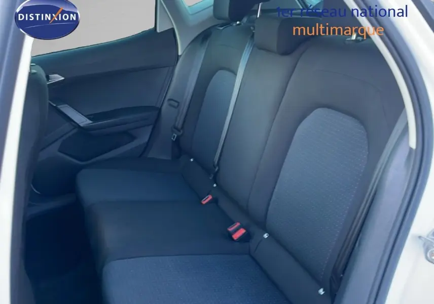 Vue intérieure côté arrière droit montrant les sièges arrière en tissu noir avec détails gris sur un SEAT Arona blanc.