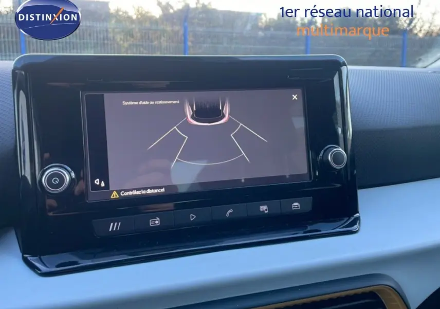 Vue intérieure du tableau de bord du SEAT Arona 2025, écran tactile affichant l'aide au stationnement.