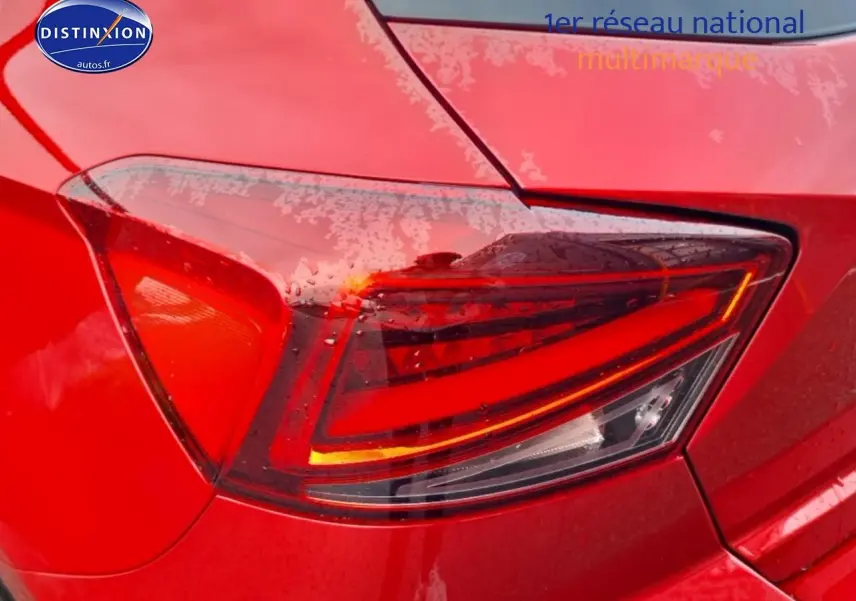 Gros plan sur le feu arrière droit rouge d’une SEAT Ibiza 1.0 TSI 95 Copa rouge désir 2025, carrosserie mouillée.