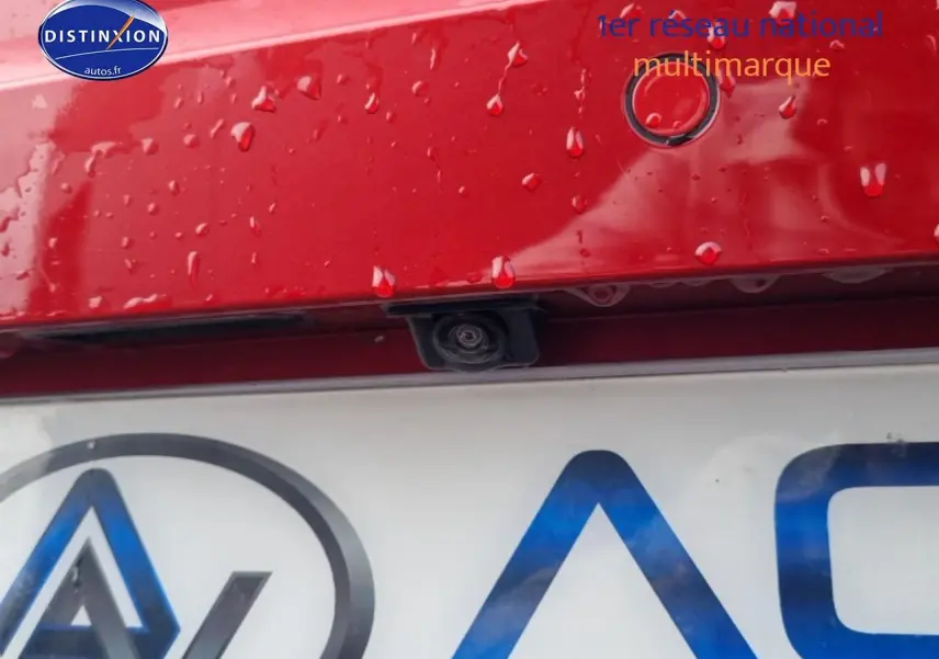 Gros plan sur la caméra de recul et le capteur de stationnement arrière d'une SEAT Ibiza rouge désir, hayon humide.