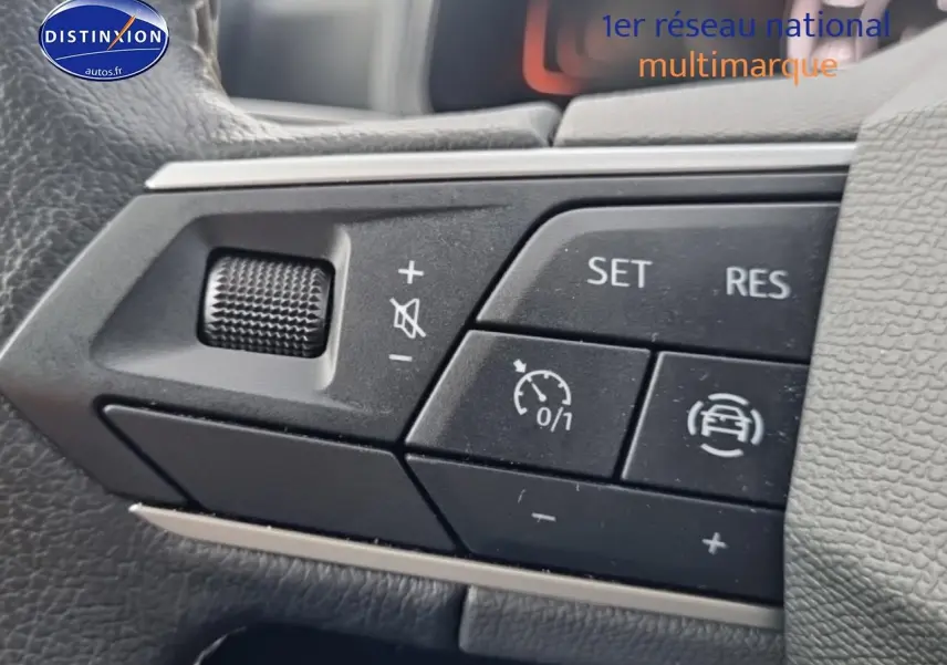 Gros plan sur les commandes de régulateur de vitesse au volant d'une SEAT Ibiza 2025, intérieur noir.