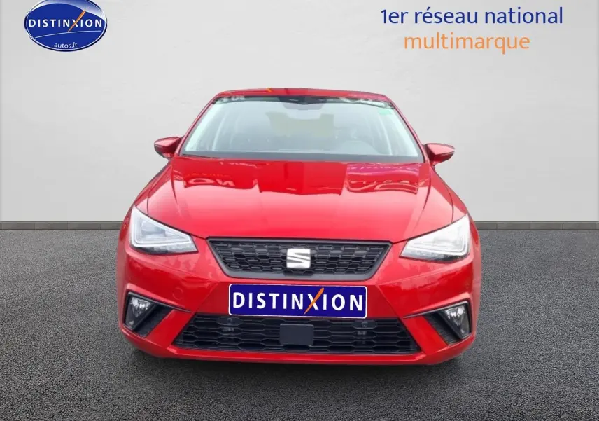 Vue frontale d'une SEAT Ibiza rouge désir 2025 avec calandre noire et phares LED triangulaires.