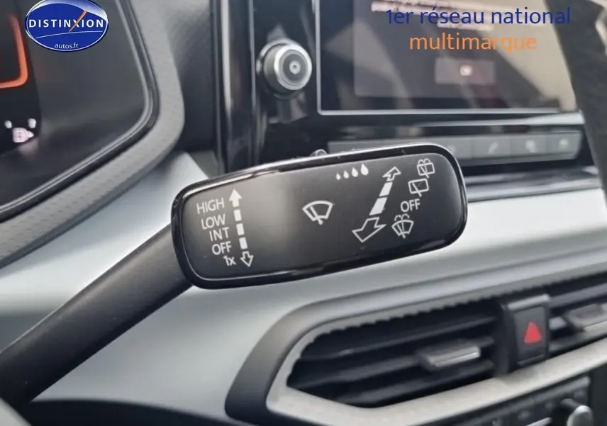 Gros plan sur la commande d’essuie-glace dans l’habitacle gris clair de la SEAT Ibiza 2025 rouge désir.
