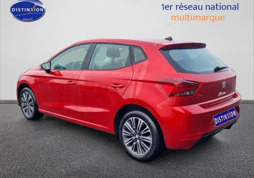 Vue 3/4 arrière droite d'une SEAT Ibiza rouge désir avec jantes alliage et feux arrière LED distinctifs.
